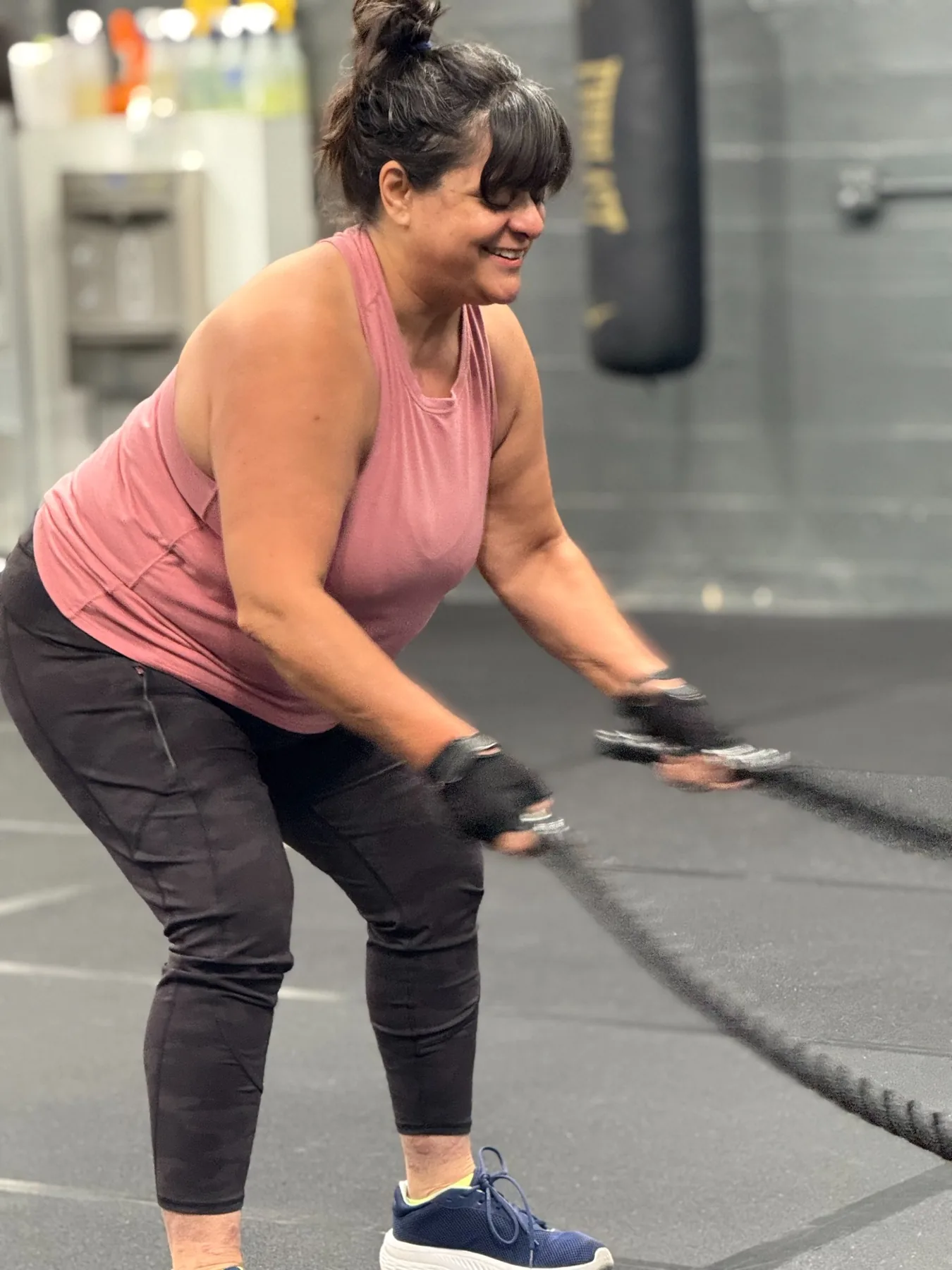 Woman smiling while training with battle ropes
